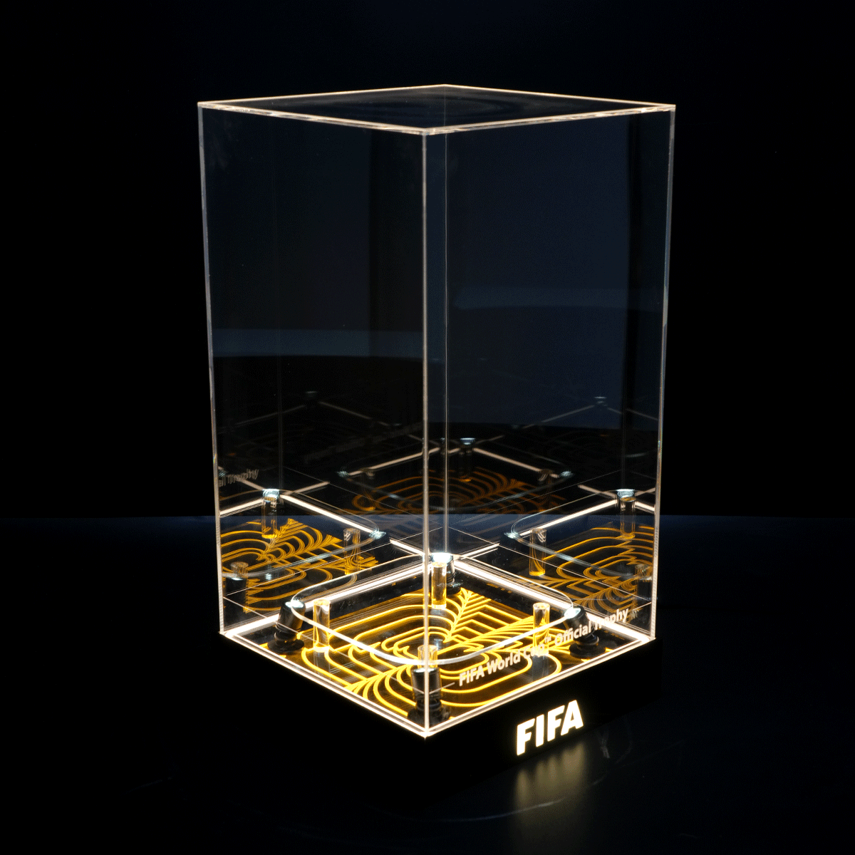Clear acrylic trophy with a glowing orange patterned base and FIFA lettering on the front edge area.