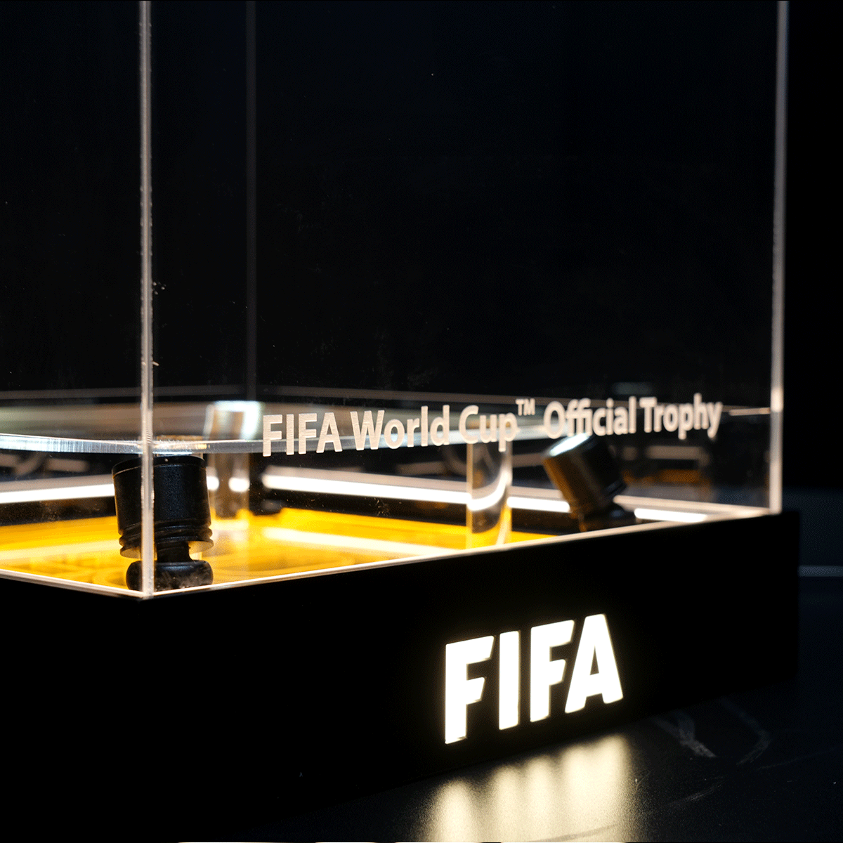 FIFA World Cup Official Trophy on display inside a glass case with a black base and illuminated pedestal area