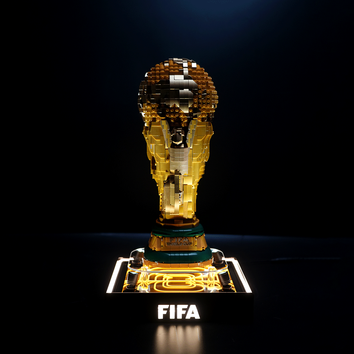LEGO brick sculpture of the FIFA World Cup trophy on a glowing base with 