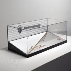 Clear glass display case with a black base, featuring a Koenigsegg logo on the side for showcasing a model car or memorabilia.