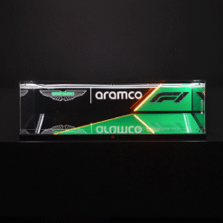 Long rectangular glass display with Aston Martin and Aramco branding, green and orange neon lines against a dark background (F1 graphic).