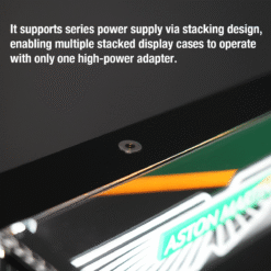 Close-up of a power supply module on a sleek display case, illustrating stacking capability for multiple displays with one adaptor already in use.