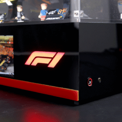 Black display case with a glowing pink-red F1 logo on the front, and miniature figures visible on the top shelf.