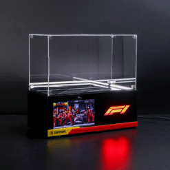 Clear acrylic display case atop a black base with Ferrari branding and a lit race image on the front panel.