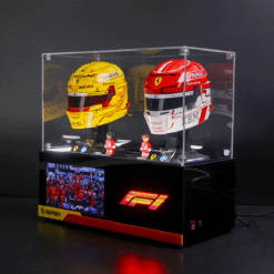 Two Ferrari Formula 1 helmets (yellow and red) showcased in a glass display case atop a black pedestal with a glowing F1 logo.