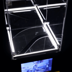 Illuminated glass cube with white LED edges intersecting at right angles against a dark background.