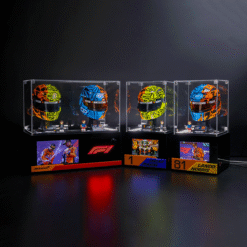 Three colorful Formula 1 helmets showcased in clear glass display cases on a dark backdrop, with race podium signs below.